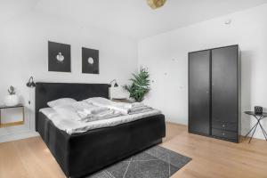 a bedroom with a bed and a black cabinet at City Square Hotel Apartments in Copenhagen