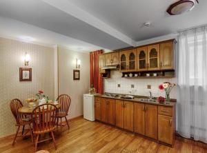 a kitchen with wooden cabinets and a table and chairs at Khreschatyk Suites in Kyiv