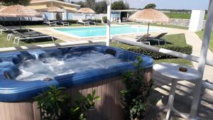 una vasca blu seduta accanto alla piscina di Case vacanza Gli Oleandri a Otranto