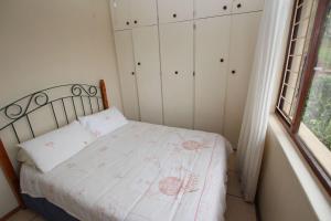 a bedroom with a bed and a window and white cabinets at Surf and Sand - Fish Eagle in Ramsgate