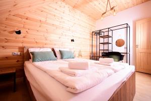 a bedroom with a large bed with two laptops on it at Apartamenty Naturapart in Dziwnów