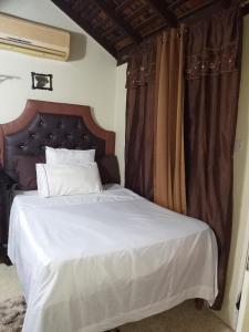 a bedroom with a large white bed with curtains at Barbican cozy Flat at dillsbury in Kingston