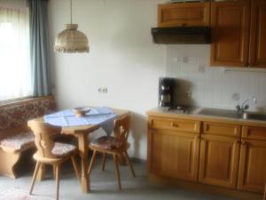 eine Küche mit einem Tisch, Stühlen und einem Waschbecken in der Unterkunft Appartement Huber in Pertisau
