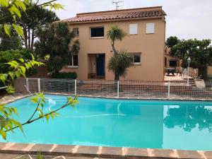 a villa with a swimming pool in front of a house at BELLE VILLA AVEC PISCINE in Sainte-Marie-la-Mer