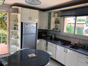 a kitchen with a refrigerator and a table in it at BELLE VILLA AVEC PISCINE in Sainte-Marie-la-Mer