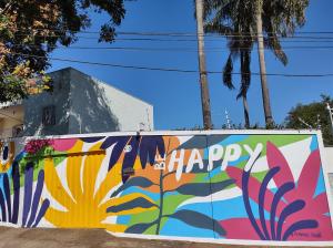 una pared cubierta de coloridos graffitis con las palabras felices en Pousada Happy Inn, en Campinas