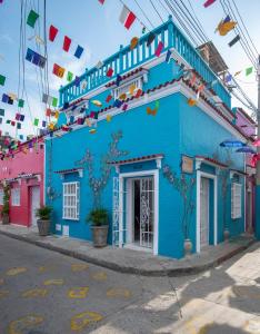 een blauw gebouw aan de straatkant bij La Casita Azul Cozy Colonial House at Centro Historico with Rooftop and Jacuzzi in Cartagena
