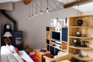 uma sala de estar com prateleiras de madeira e uma televisão em Ermitage Crestet (Ventoux - Provence) em Crestet