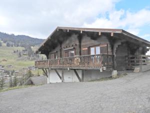 a house with a balcony on the side of a hill at 1 Authentique chalet, le Mirador in Les Gets