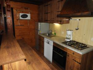 a kitchen with a stove top oven next to a sink at 1 Authentique chalet, le Mirador in Les Gets