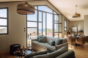 a living room with a couch and a large window at Le Garage Biarritz Hôtel in Biarritz