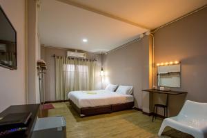 湄林First Residence的一间带床、书桌和桌子的酒店房间 sidx sidx