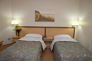 2 camas en una habitación pequeña con 2 lámparas en Hotel Augusta Boulevard en São Paulo