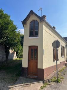 a small house with a wooden door on a street at La Bassurelle in Saint-Valéry-sur-Somme