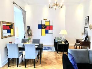Luxury Suites & Apartments MONDRIAN Market Square II في وارسو: غرفة طعام وغرفة معيشة مع طاولة وكراسي