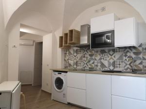 a kitchen with a washing machine and a microwave at L'Angolo dei Cavalieri in Pisa