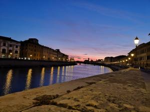 a river at night with buildings and street lights at L'Angolo dei Cavalieri in Pisa