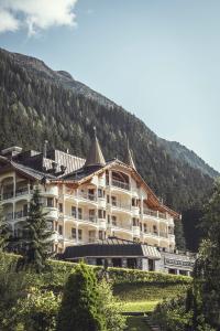 a large building on a hill with a mountain at Schlosshotel Ischgl 5-Sterne Superior in Ischgl