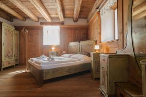 Un dormitorio con una cama grande y una ventana en Maso Franceschella, en Carano
