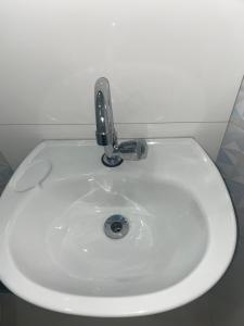 een witte wastafel met een kraan in de badkamer bij M Hotel in Sao Paulo