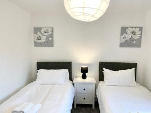 - 2 lits installés l'un à côté de l'autre dans une chambre dans l'établissement Culduthel Cottage, à Inverness