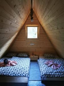 a bedroom with two beds in a wooden attic at U KONC in Stahovica