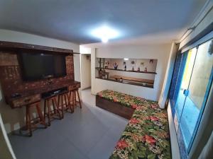 a living room with a flat screen tv and a couch at Casarão Familiar Eixo Cabo Frio Buzios com piscinão in Cabo Frio