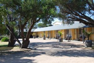 un edificio con un árbol delante de él en Rye Beach Motel Australia, en Rye