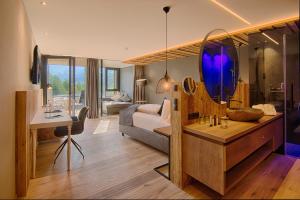 a bedroom with a bed and a desk with a mirror at Amonti Wellnessresort in Cadipietra