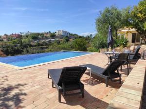 a patio with a table and chairs next to a pool at Villa 3 Quartos, Piscina, AC, Vista Mar, Prestige For Home in Loulé