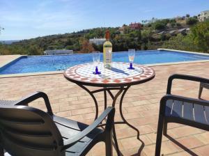 a table with a bottle of wine and two chairs at Villa 3 Quartos, Piscina, AC, Vista Mar, Prestige For Home in Loulé