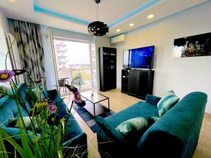 a living room with a blue couch and a tv at Apartament z tarasem i widokiem na Odrę in Wrocław