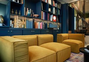 uma sala de estar com duas cadeiras e um sofá em Hôtel Amoi Paris em Paris