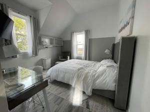 1 dormitorio con cama y mesa de cristal en Pleasant Street Inn, en Parrsboro