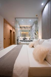 a large white bed with furry pillows on it at Suite Hotel in Kemerovo