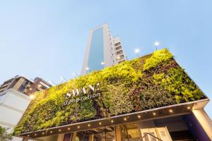 a building with a green wall on top of it at Swan Generation Porto Alegre in Porto Alegre