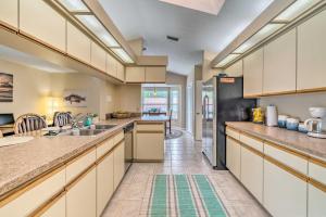 a kitchen with white cabinets and a black refrigerator at Waterfront Home with Dock, Kayaks, Pool and More! in Crystal River