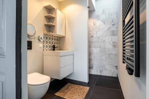 a small bathroom with a toilet and a sink at Hosted by Wendy Prins Willem 3 in Scheveningen +22 photos