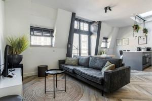 a living room with a couch and a kitchen at Hosted by Wendy Prins Willem 3 in Scheveningen