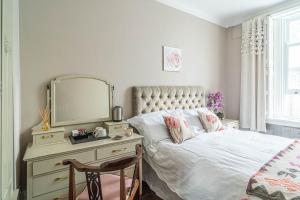 a bedroom with a bed and a dresser with a mirror at House close to kings cross in London