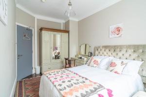 ein Schlafzimmer mit einem weißen Bett mit einer rosa und weißen Decke in der Unterkunft House close to kings cross in London