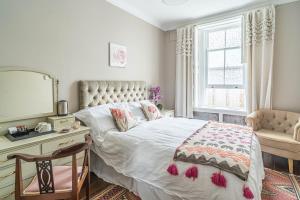 a bedroom with a bed and a desk and a mirror at House close to kings cross in London