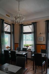 une salle à manger avec des tables et des chaises ainsi qu'un lustre dans l'établissement Leutesdorfer Hof, à Leutesdorf