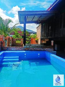a large blue swimming pool in front of a house at Che'Pa Village Langkawi in Kuah