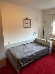 a bedroom with a bed and a clock on the wall at Appartement à l'ange in Climbach