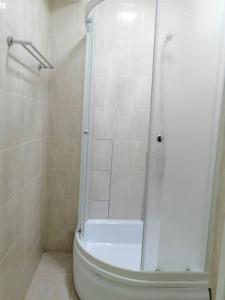 a bathroom with a shower and a white toilet at Apart Hotel 36 этаж in Astana +9 photos