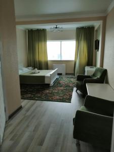 a living room with a bed and a couch and chairs at Apart Hotel 36 этаж in Astana