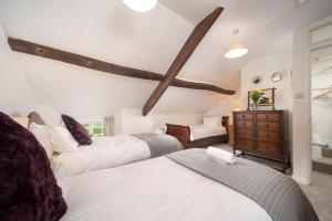 a bedroom with two beds and a dresser at Diana's Cottage in Braunton