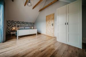 sypialnia z łóżkiem i drewnianą podłogą w obiekcie Sun House w mieście Nadole