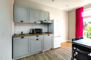 een keuken met witte kasten en een tafel in een kamer bij à la fontaine in Druskininkai +5 foto's